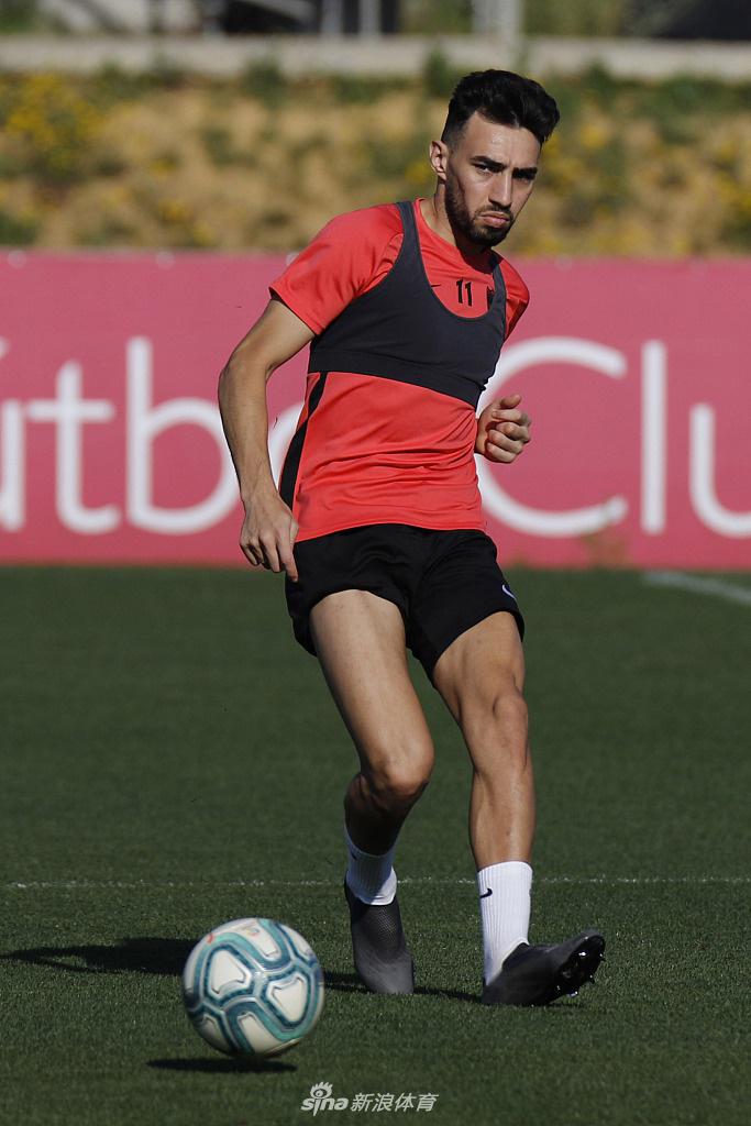 一名塞维利亚球员正在进行标志盘绕杆训练，他专注的目光紧盯着脚下的皮球，湿透的球衣紧贴在背上，折射出五月安达卢西亚的骄阳与复训的强度。