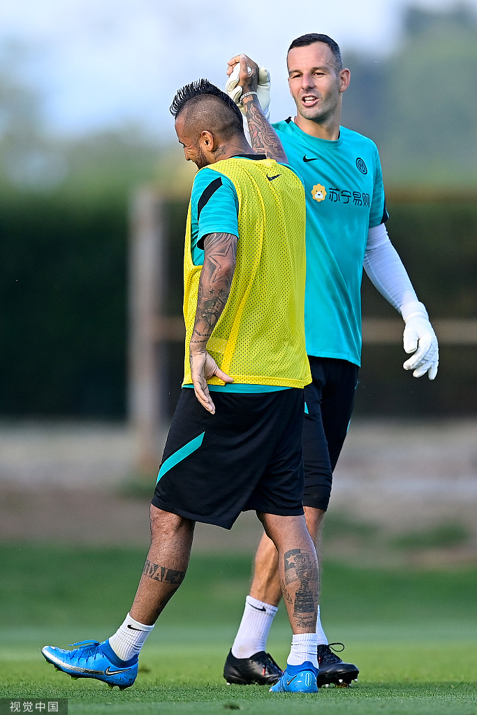 训练结束后的比达尔神情轻松，与队友谈笑风生，夕阳的余晖洒在他身上，为即将踏上征途的勇士镀上了一层金色的光芒。