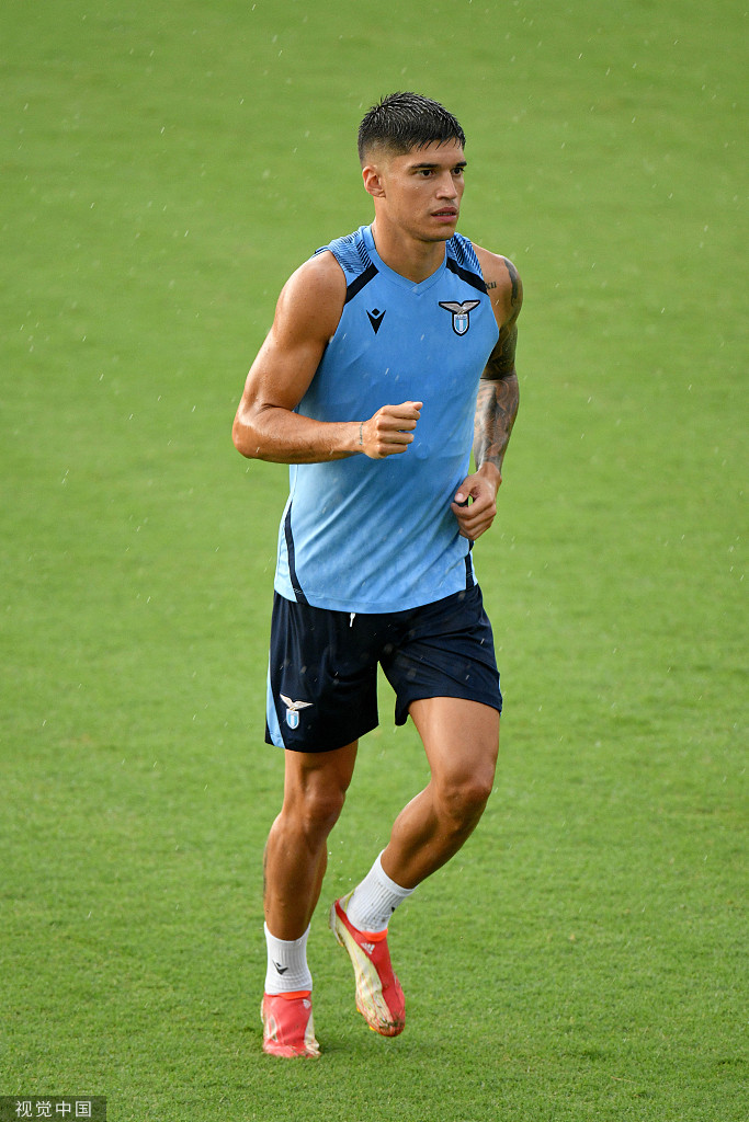 因莫比莱低头凝视脚下的足球，仿佛在思考如何用萨里的战术体系攻克下一个对手的防线，神情专注而深邃。