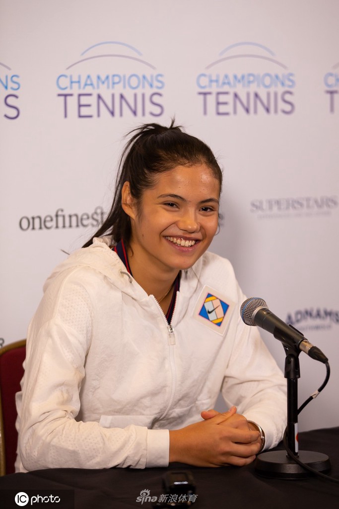 尽管是表演赛后的发布会，拉杜卡努依然保持着极佳的状态，手持话筒的她面带微笑侃侃而谈，展现出超越年龄的职业风范，身后的背景板映衬出这次活动的特别意义。