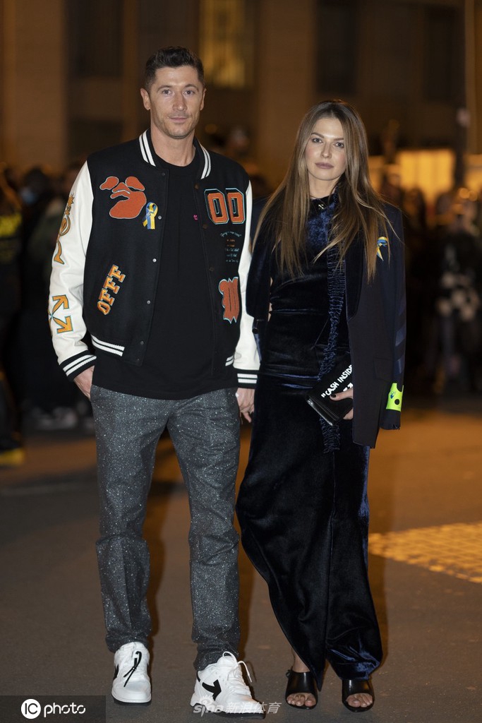 莱万与安娜站在塞纳河畔的建筑前合影，夕阳余晖为两人勾勒出金色的轮廓，他们相视而笑，仿佛时间在此刻为他们停留。