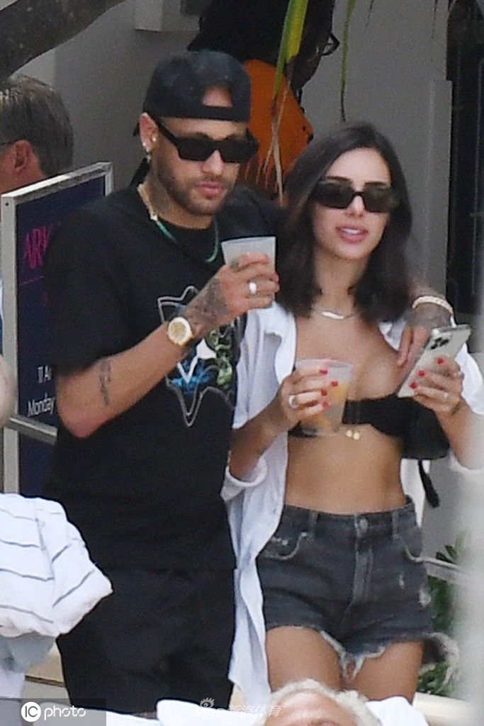 内马尔与女友布鲁娜在迈阿密海滩深情对视，海风拂过，两人脸上洋溢着无忧无虑的幸福笑容。