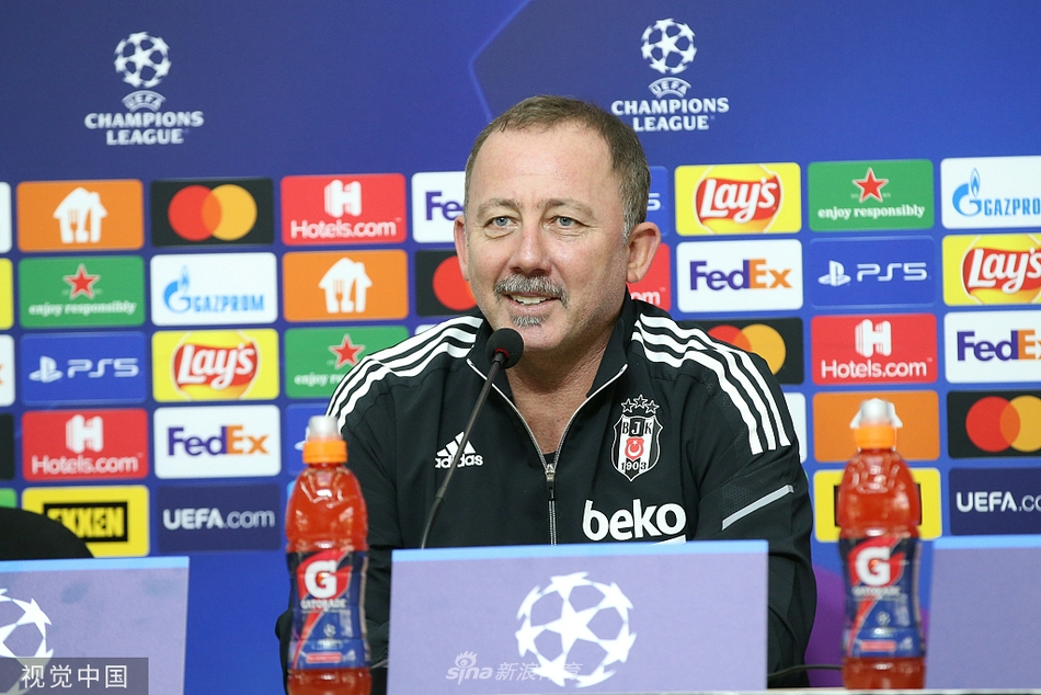 在伊斯坦布尔午后暖阳的映照下，贝西克塔斯队的主教练身着深色正装，神情专注而严肃地坐在发布会台上，身前麦克风林立，他正用手势强调着明日对阵多特蒙德的战术要点，目光如炬，仿佛已将整个球场纳入胸中。