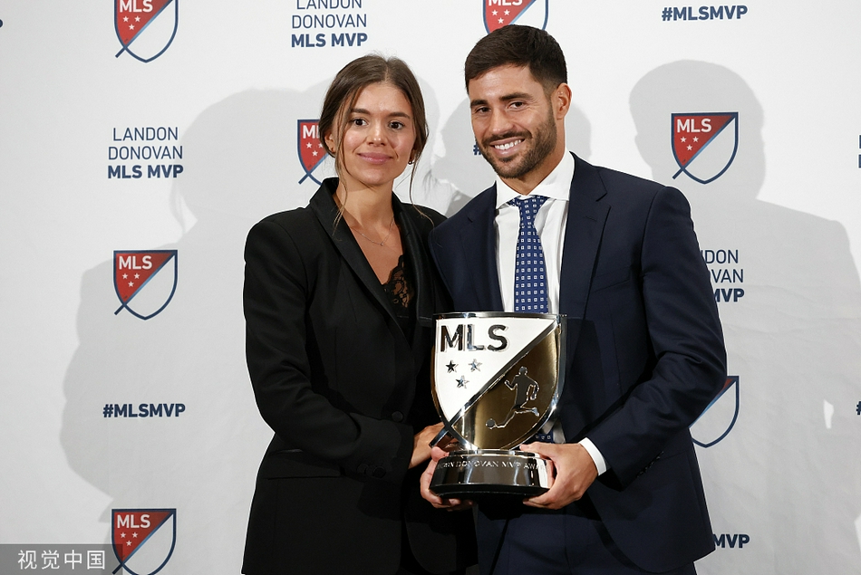 纽约城FC队员们在夺冠后紧紧相拥，脸上混杂着雨水、汗水和喜悦的泪水，背景是漫天飞舞的蓝色纸带。