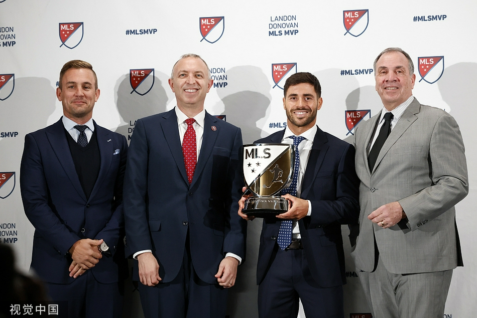 颁奖典礼现场，一位获奖者正在发表感言，背景大屏幕映照出他荣耀的身影，台下是星光熠熠的同行观众。