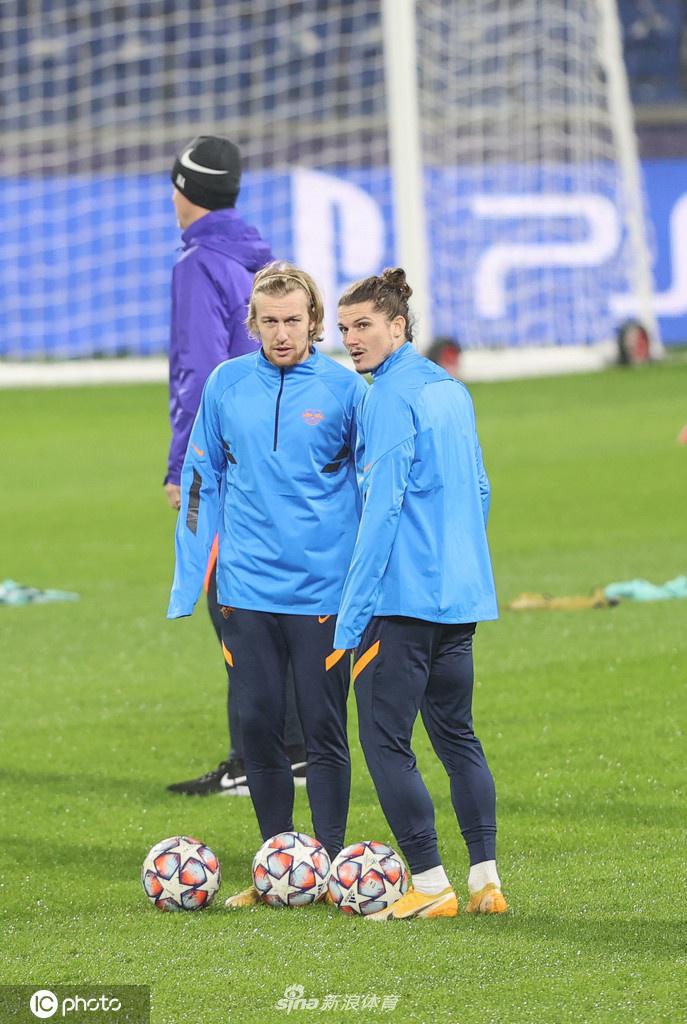 训练场上，一名莱比锡红牛球员正在进行高强度的有氧跑动，他身后的队友们散落在广阔的绿茵场上。汗水早已浸湿了他的训练服，每一次呼吸在冬日的空气中凝成白雾，彰显着备战背后的艰辛与付出。