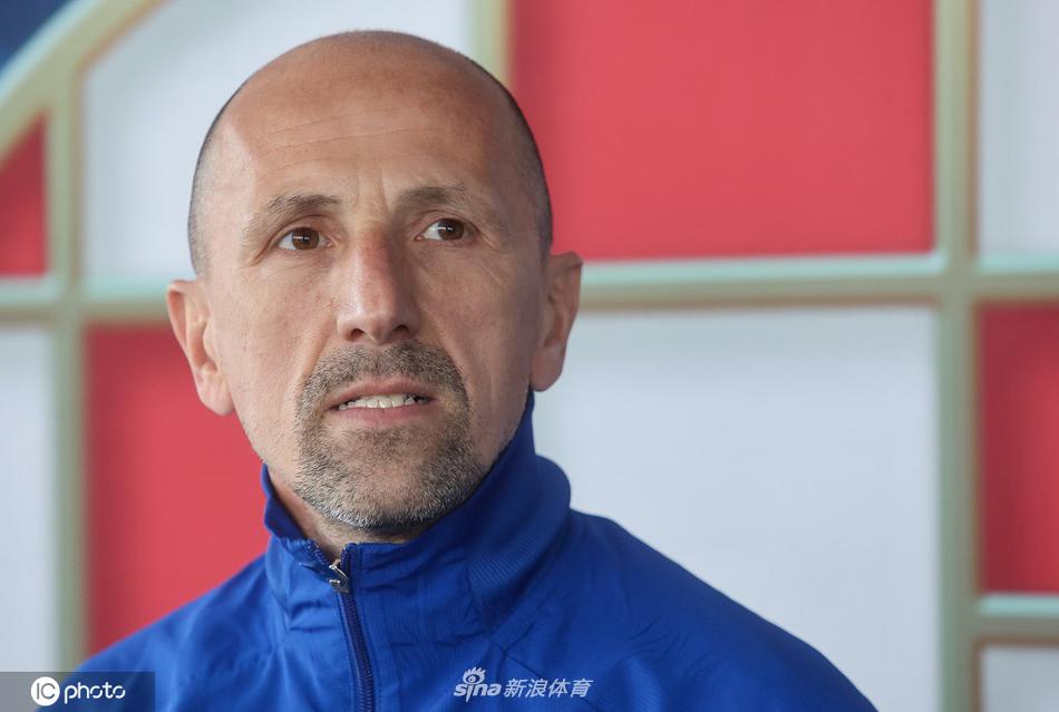 发布会现场全景，一排排话筒整齐地摆放在桌上，对准了即将发言的球队代表。长焦镜头下，媒体席上的记者们正全神贯注地记录，空气中弥漫着大战来临前特有的紧张与兴奋。