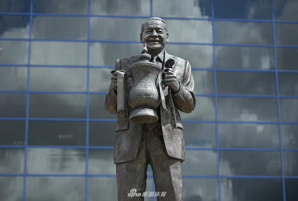 西看台外部的玻璃幕墙反射着天空的云朵，这里不仅是球员的更衣室所在地，更藏着俱乐部的行政中枢与荣誉室，玻璃上隐约映出对面空旷的停车场，透出赛日之外的片刻宁静。