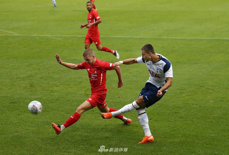 莱顿东方球员在禁区内争抢头球，他奋力跃起，身体在空中完全舒展，眼神紧紧盯着飞来的皮球，防守球员则在他身旁试图干扰。