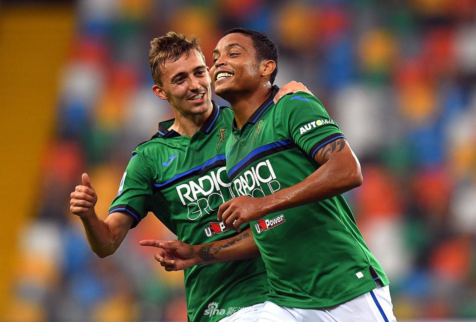 终场哨响后，打入两球的穆里尔与队友戈麦斯击掌相庆，他们的脸上洋溢着胜利的喜悦，身后是空旷的看台。