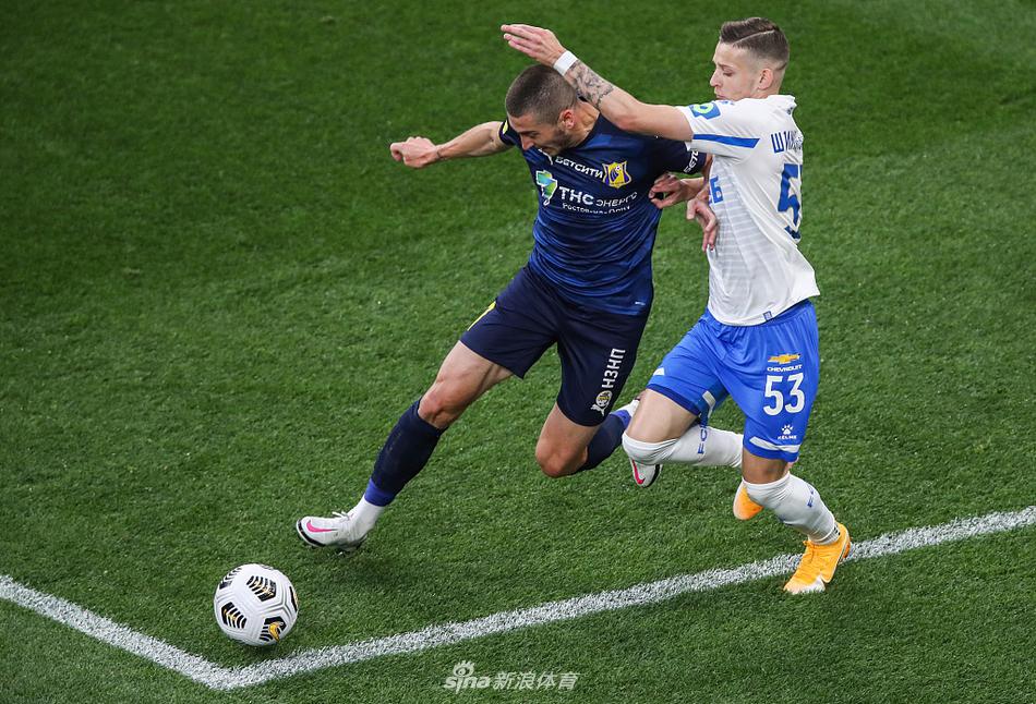 从高处俯瞰VTB竞技场，绿茵场如同一块巨大的翡翠，球员们散落其上如同棋子，空荡荡的看台与明亮的灯光形成对比，营造出一种独特而庄严的赛场氛围。