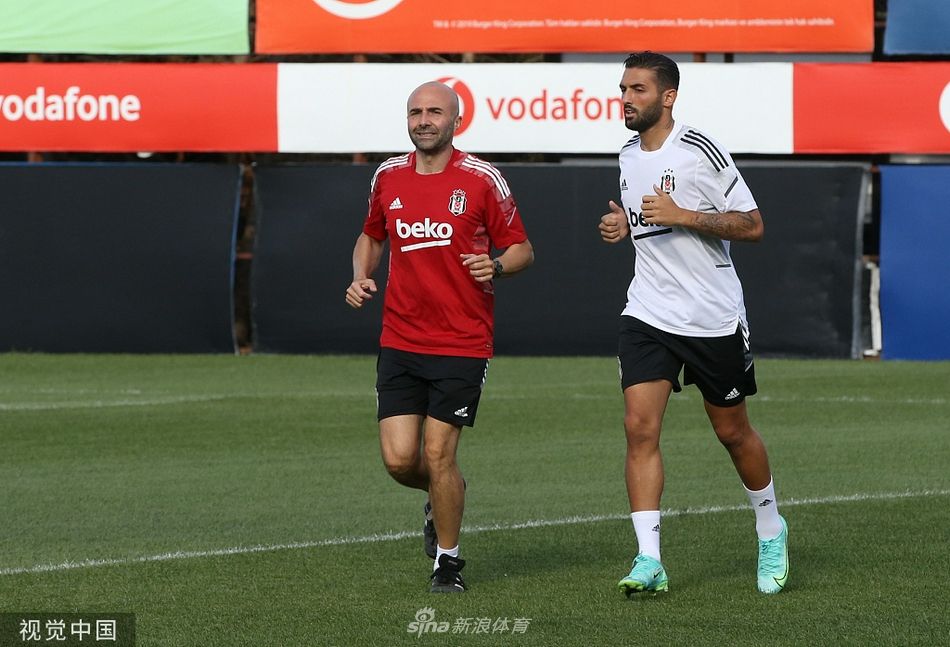 空旷的新闻发布会厅内，工作人员正在进行最后的整理。主席台上的座椅整齐排列，每个座位前的矿泉水瓶和话筒都在静静等待。背景板上巨大的欧冠官方标志和贝西克塔斯队徽交相辉映，提醒着每一个人，这里即将发生一场关乎荣誉的欧洲顶级对话。