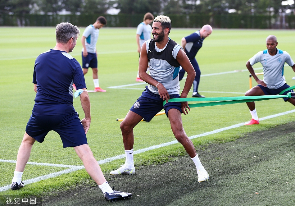 训练场上空，一架无人机航拍下了城市足球学院的全貌。在盛夏澄澈的天空下，几块顶级的训练草坪如同绿色的地毯般铺开，球员们的身影在其上星罗棋布，构成了一幅充满生机与活力的现代化足球训练画卷。