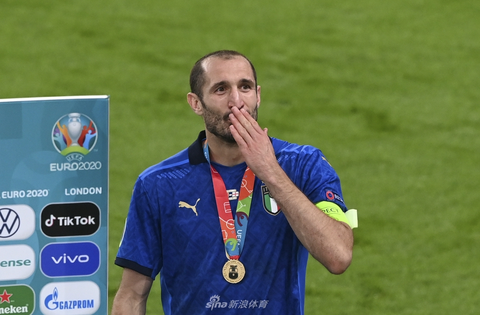 基耶利尼和博努奇这对老友紧紧相拥，脸上带着笑意与沧桑，他们身披的蓝色战袍因汗水而紧贴，仿佛将意大利的钢铁防线烙印在了身上。