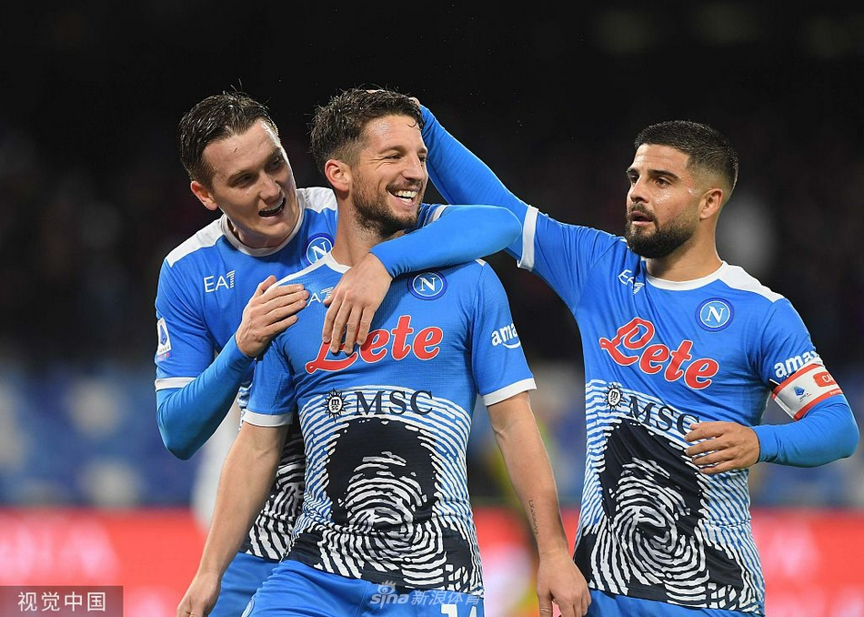 在烟雾与灯光下，那不勒斯球员们围成一团激情庆祝进球，背景是看台上沸腾的球迷，仿佛整个马拉多纳球场都在为他们呐喊助威。