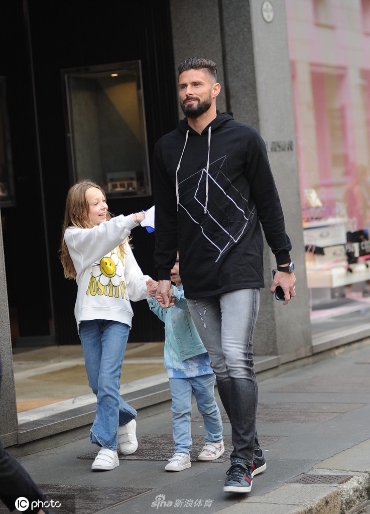 吉鲁与家人手提购物战利品，结束悠闲午后，背影温馨而满足