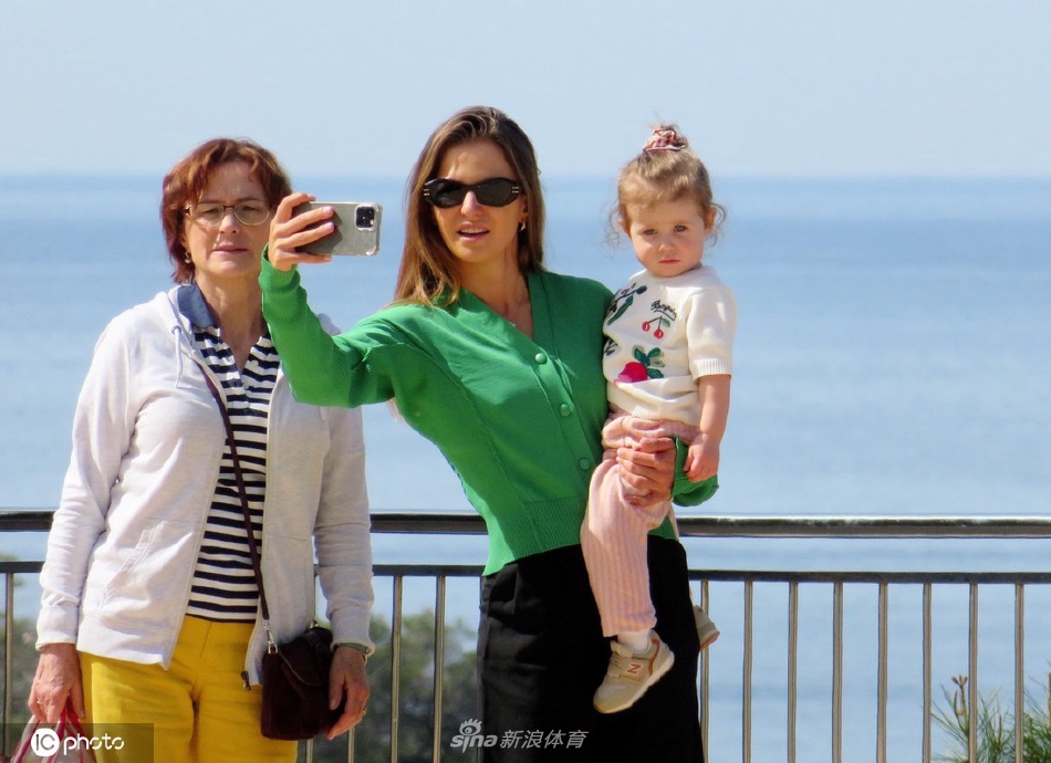 安娜与家人漫步于马略卡岛风景如画的步道，背后是蔚蓝辽阔的地中海，画面充满了悠闲幸福的假日气息。