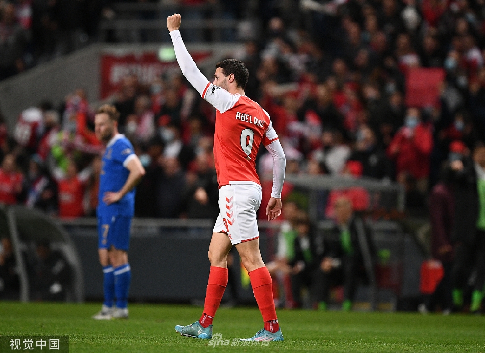 布拉加队球员张开双臂狂奔庆祝进球，身后是呆立的流浪者队防守球员和一片狂喜的红色主场看台。