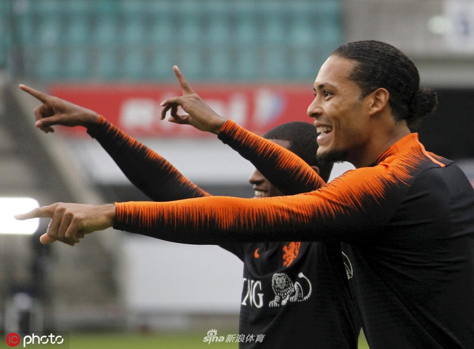 主帅科曼神情专注地给弟子们讲解战术板，球员们围成一圈认真聆听，眼神中透露出对比赛胜利的渴望和战术纪律的尊重。