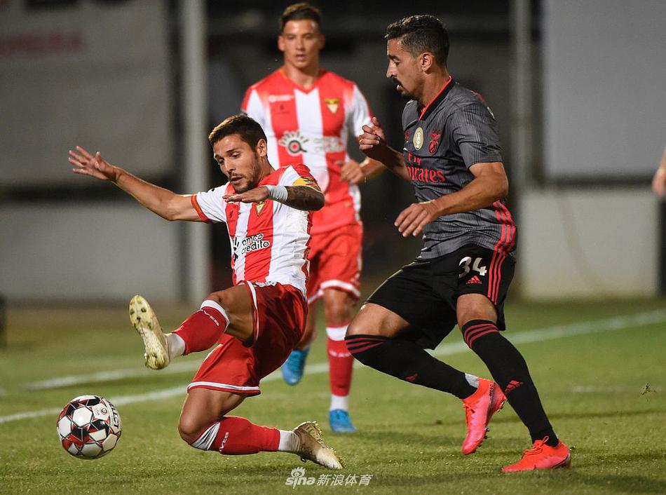 本菲卡队球员皮齐主罚点球瞬间，他目光坚毅，全场目光聚焦于他与足球之上，球门后的看台空空荡荡，更凸显了这一刻的紧张与专注。