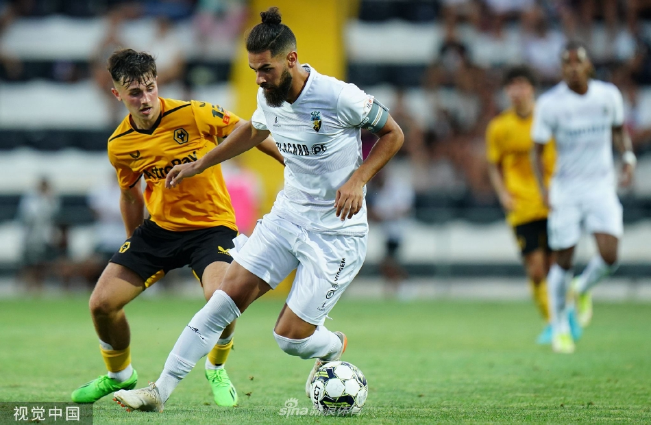 狼队中场核心在对方多人包夹下冷静控球，眼神锐利地观察前方，寻找撕裂防线的传球路线，尽显大将风范。