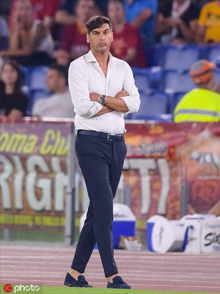 保罗-丰塞卡在场边专注指挥，眉头微蹙，修身的西装勾勒出他挺拔的身形，仿佛不是身处喧嚣的球场，而是置身于米兰的时装秀场。