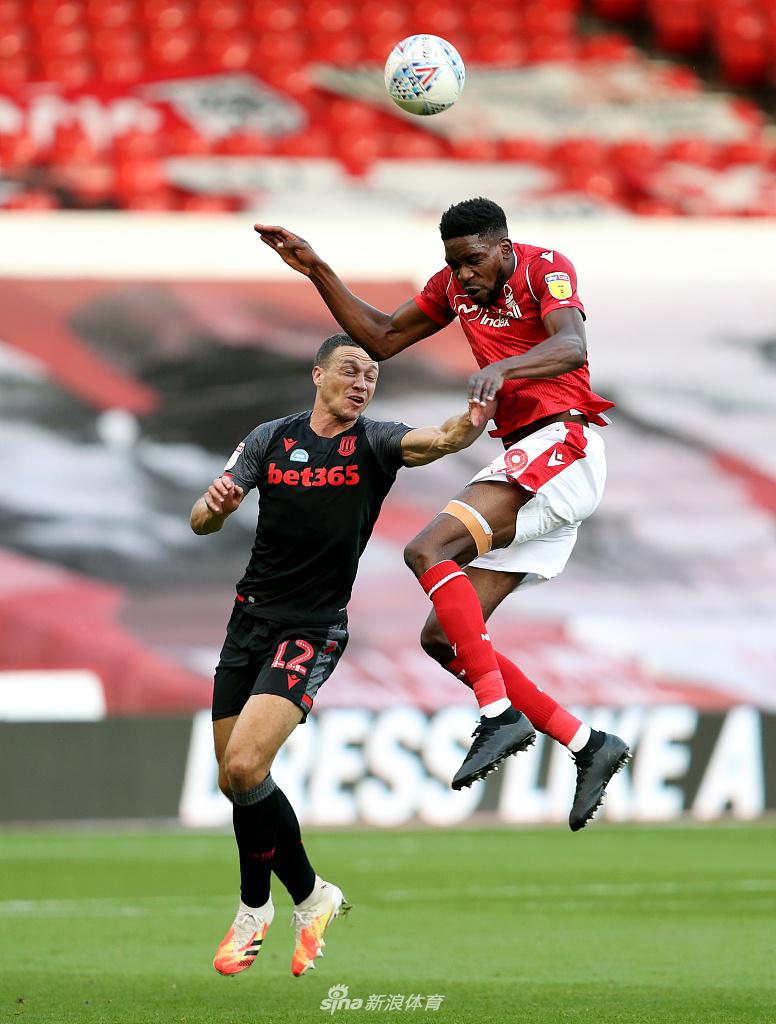 诺丁汉森林门将乔丹·史密斯无奈地从球门里捡出皮球，背景是斯托克城球员欢庆的身影，他的低头沉默与对手的狂喜形成了悲喜两重天的鲜明对比。