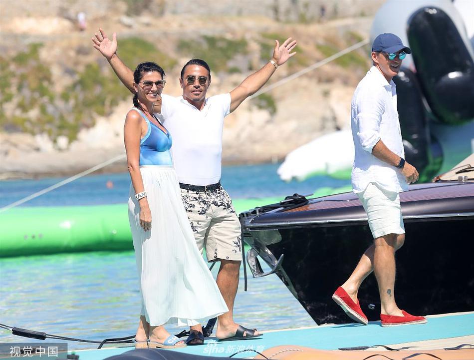 镜头定格下夫妻俩的甜蜜瞬间，身后是希腊蔚蓝的海景，幸福之情溢于言表