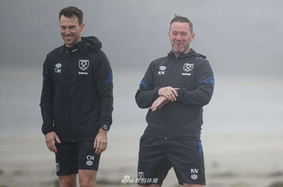 几名球员并肩奔跑在能见度极低的小路上，他们的运动服上凝结着细密的水珠，脸上却带着轻松的笑容，互相加油鼓劲。背景中的树木和建筑完全消失在浓雾里，只剩下他们充满活力的身姿成为画面的绝对焦点。