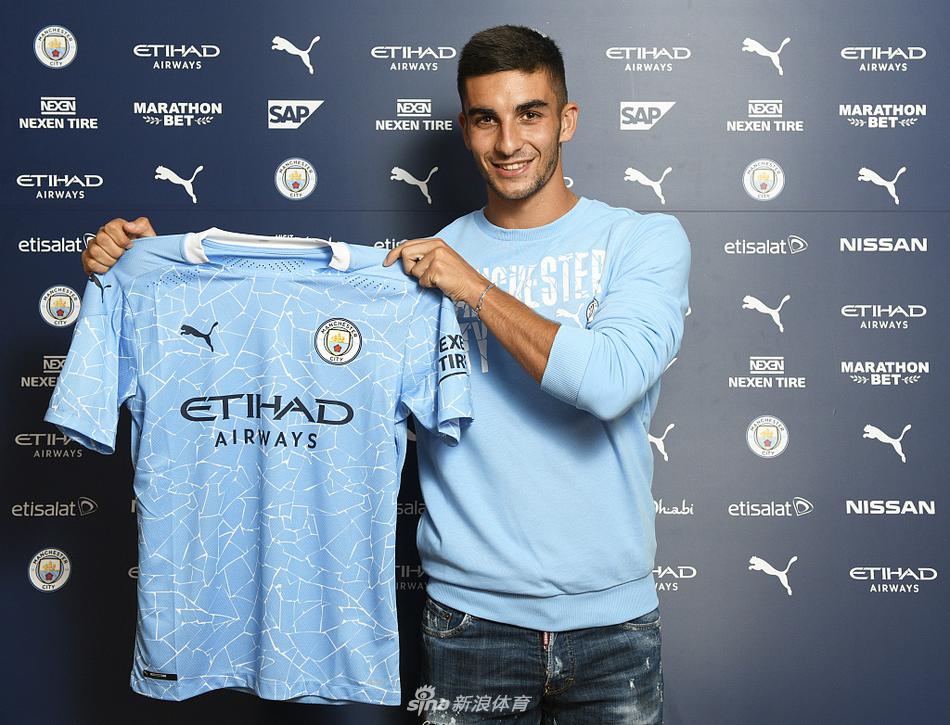 身披曼城球衣的费兰-托雷斯在亮相仪式上，年轻的西班牙边锋面带青涩而坚定的微笑，一手持曼城围巾，背后是象征新起点的伊蒂哈德球场看台。