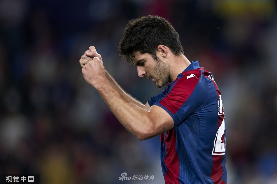 皇家社会球员大卫·席尔瓦在激烈拼抢中护住足球，莱万特防守队员紧追不舍