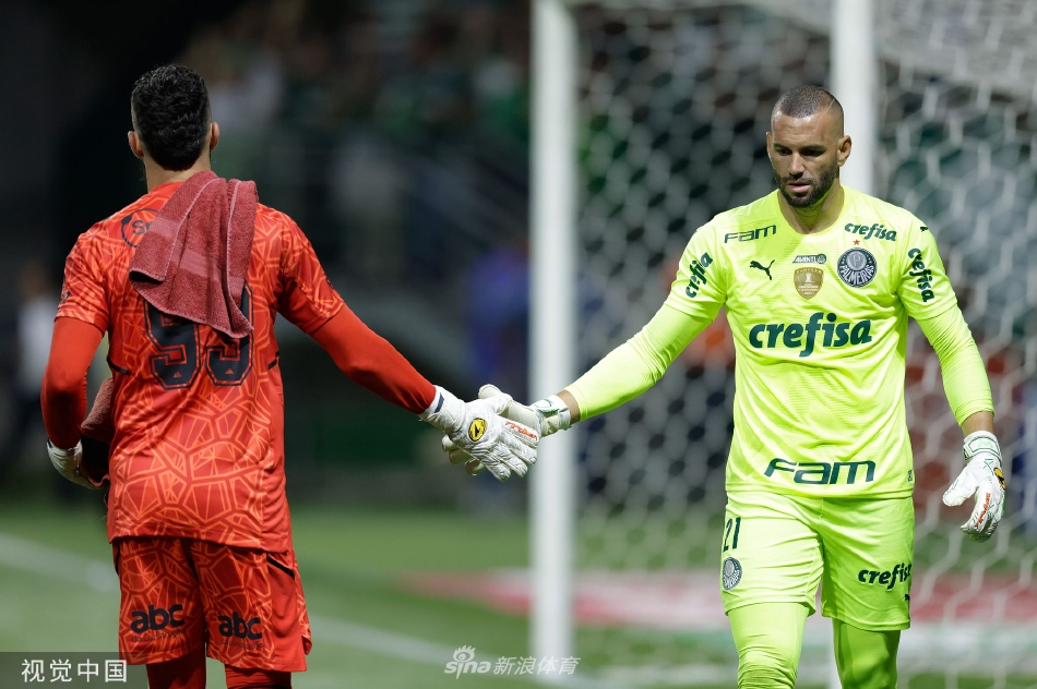 圣保罗球员进球后与队友激动相拥庆祝，背景是看台上欢呼雀跃的绿色海洋。