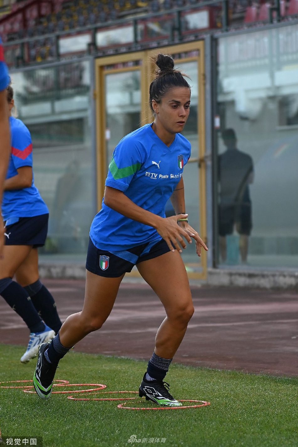 一位女足球员自信面对镜头微笑，眼中充满对比赛的期待