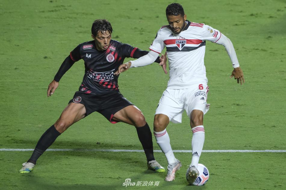 圣保罗球员完成关键铲断后与对手激烈对脚，草屑飞溅，面部紧绷的表情传递出寸土必争的决战氛围。