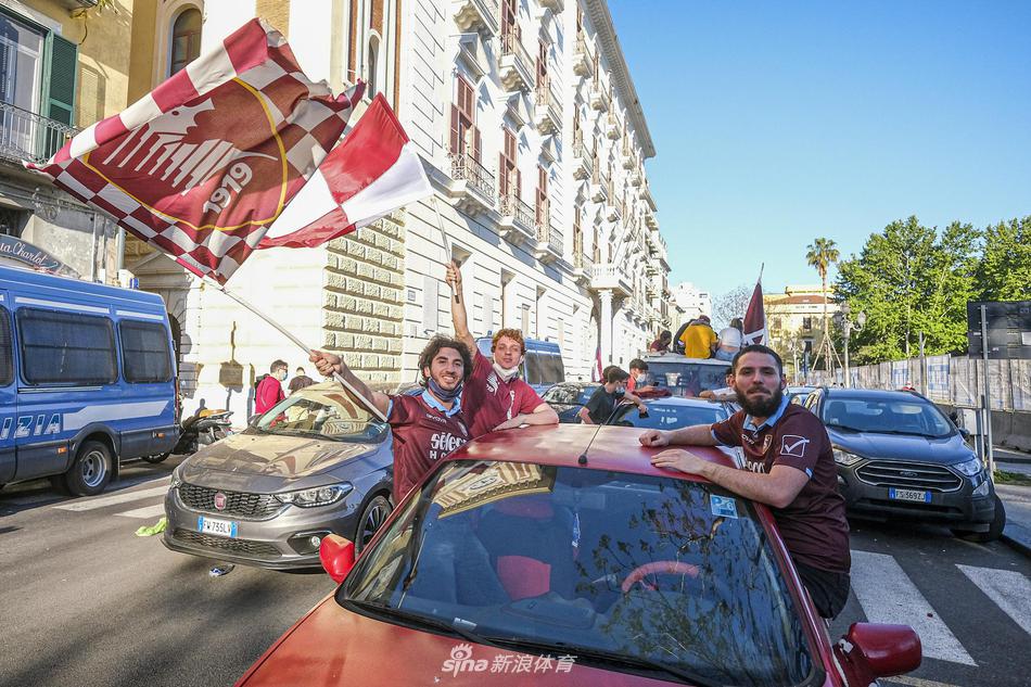  最后一张照片将目光投向了人群中的细节：一对父子坐在父亲的肩头，孩子手中高举着一条印有萨勒尼塔纳队徽的围巾，遮住了大半张脸，只露出一双充满好奇与兴奋的眼睛。足球的传承，就在这代代相传的呐喊与旗帜中无声延续。