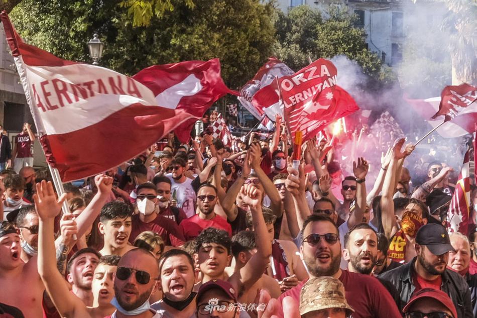  夕阳的余晖洒在萨莱诺的海滨大道上，成群结队的球迷们将街道挤得水泄不通。他们挥舞着围巾，点燃红色的烟雾弹，空气中弥漫着刺鼻却令人兴奋的火药味，整条海滨路都被染上了一层梦幻的红色光晕。