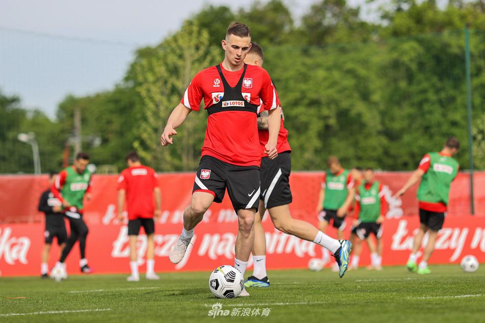 在队友们的列队注视下，莱万多夫斯基微笑着与队列中的队友一一击掌互动，阳光洒在训练场上，整个队伍洋溢着轻松、融洽却又充满凝聚力的氛围。