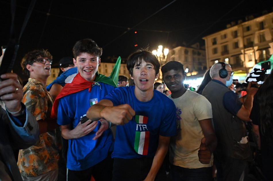 都灵的地标建筑安托内利尖塔亮起了意大利国旗的绿白红三色灯光，塔下的广场上聚集了成千上万的球迷，他们挥舞着手中的荧光棒，场面壮观而感人。