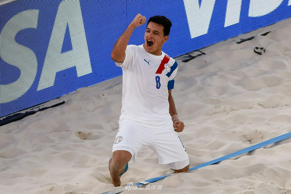 美国队门将奋力侧扑，身体完全舒展在沙地上，试图阻挡巴拉圭队的劲射，他紧咬牙关的眼神中透露出不甘与坚毅。