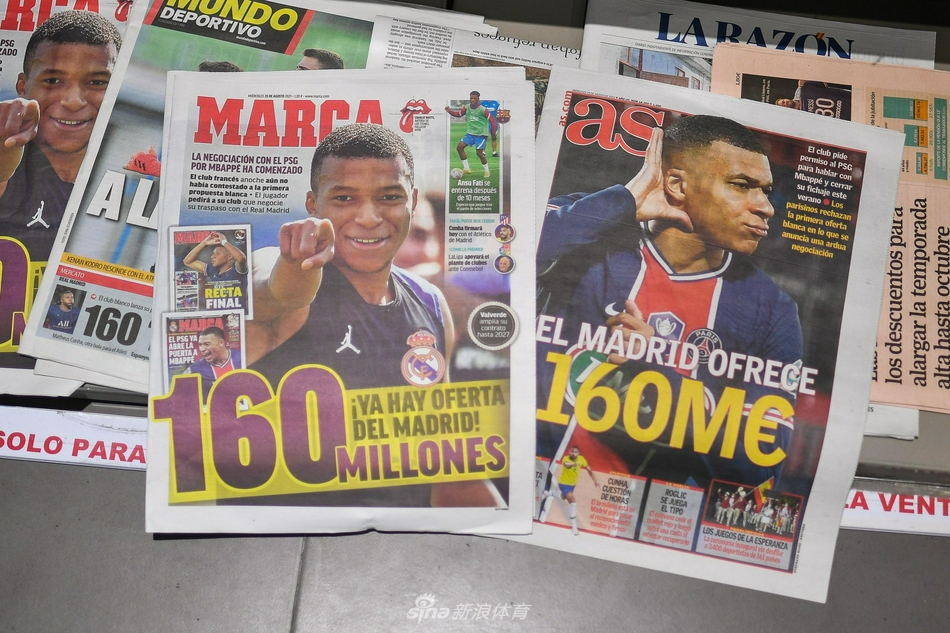 在第四个报纸版面中，姆巴佩身穿白色球衣，双手叉腰站立，眼神坚毅地望向前方。背景中的标题提到了‘疯狂的转会市场’，将这个夏天的动荡与姆巴佩个人的未来紧密相连，仿佛他正站在职业生涯抉择的十字路口。