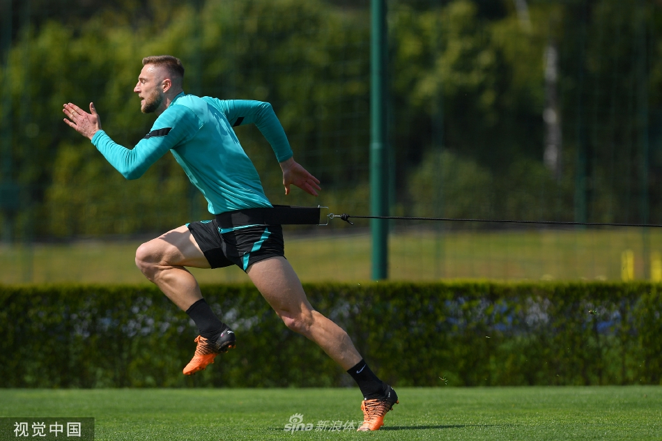 两名球员在草地上进行一对一攻防对抗，肌肉紧绷汗水飞溅，展现职业足球的力量与技巧之美