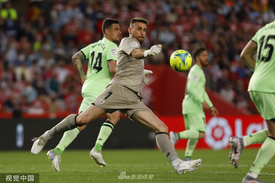 毕尔巴鄂竞技球星伊尼亚基·威廉姆斯带球强行突破，两名格拉纳达防守球员左右夹击，三人肌肉碰撞间展现着足球的力量与对抗之美。