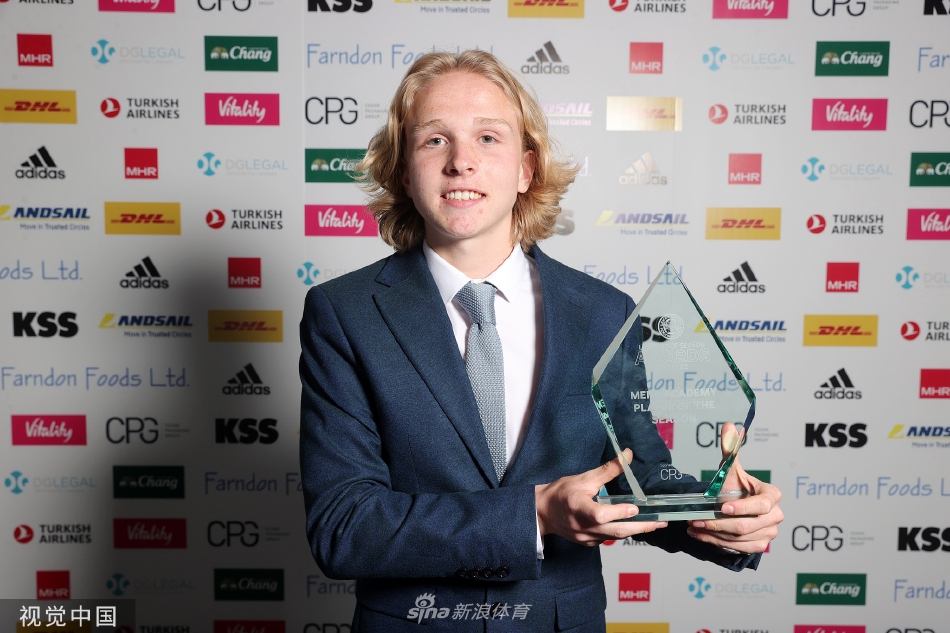 莱斯特城女足队员香农·奥布莱恩在领奖台上手持奖杯，她的杰出表现是女队成功保级的关键。