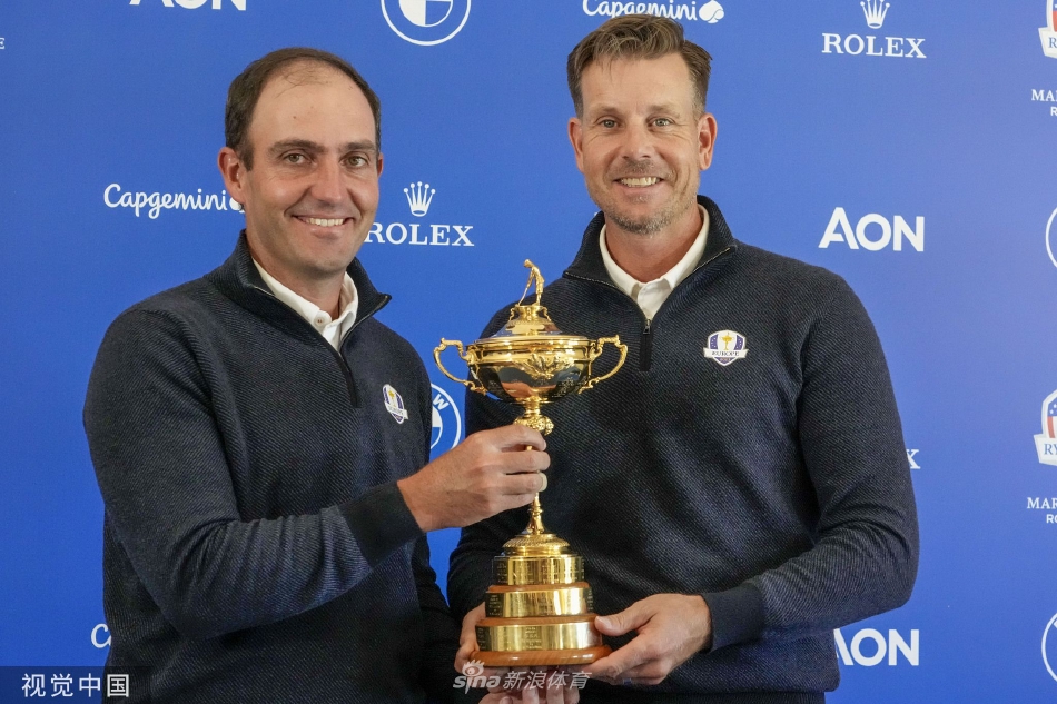 斯滕森与团队官员及嘉宾站在台上，他身着深色西装，侧身倾听旁人发言，奖杯静静置于台前，现场气氛正式而严肃。