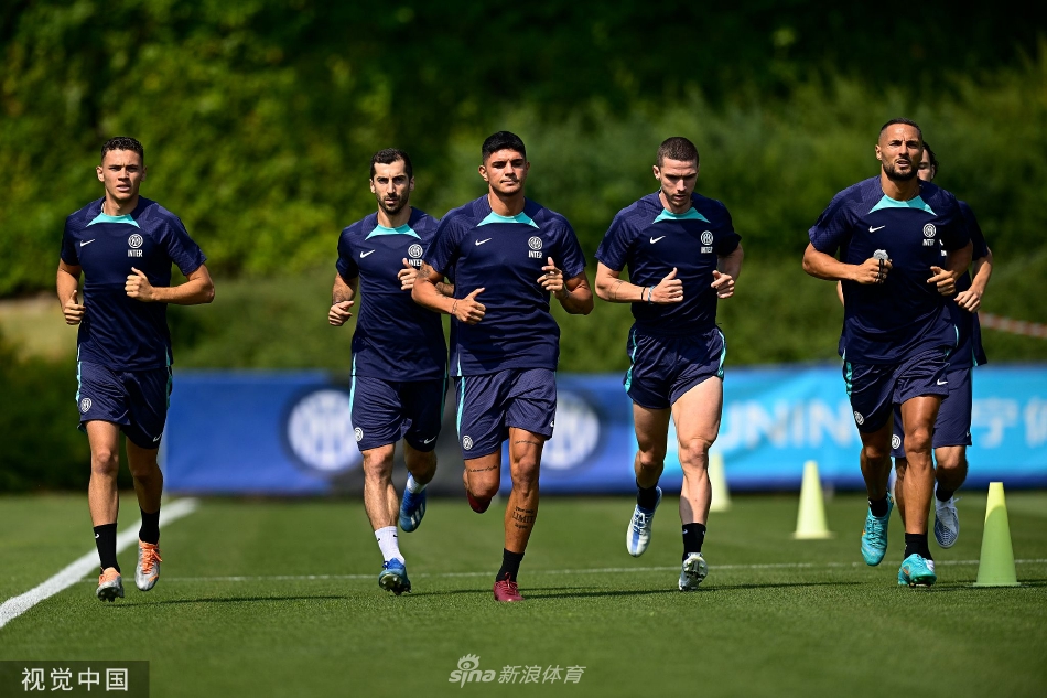 两名年轻球员在慢跑中低声交流，脸上带着笑容，展现了更衣室内轻松愉快又积极向上的团队氛围。