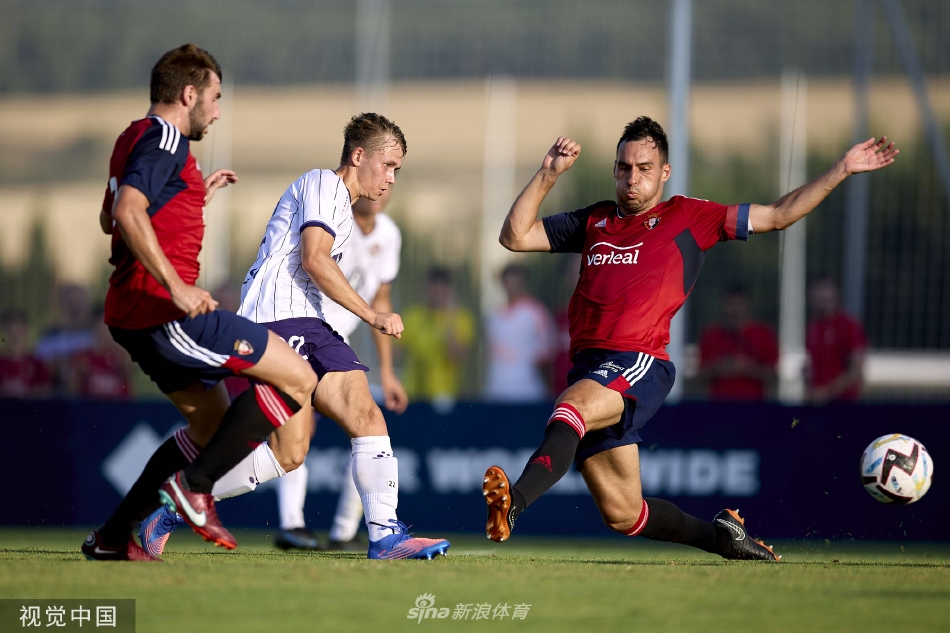 奥萨苏纳球员主罚任意球，人墙高高跃起，皮球从人墙边缘绕过直飞球门死角。