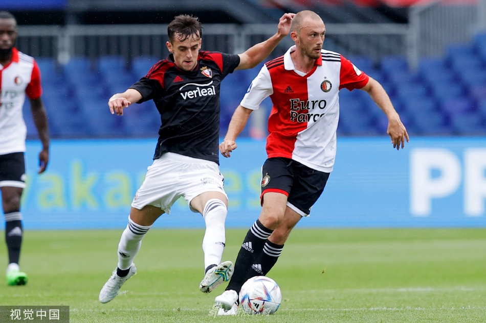 双方球员中场激烈拼抢，球鞋激起草皮，汗水在阳光下闪烁，展现着足球最纯粹的对抗之美。