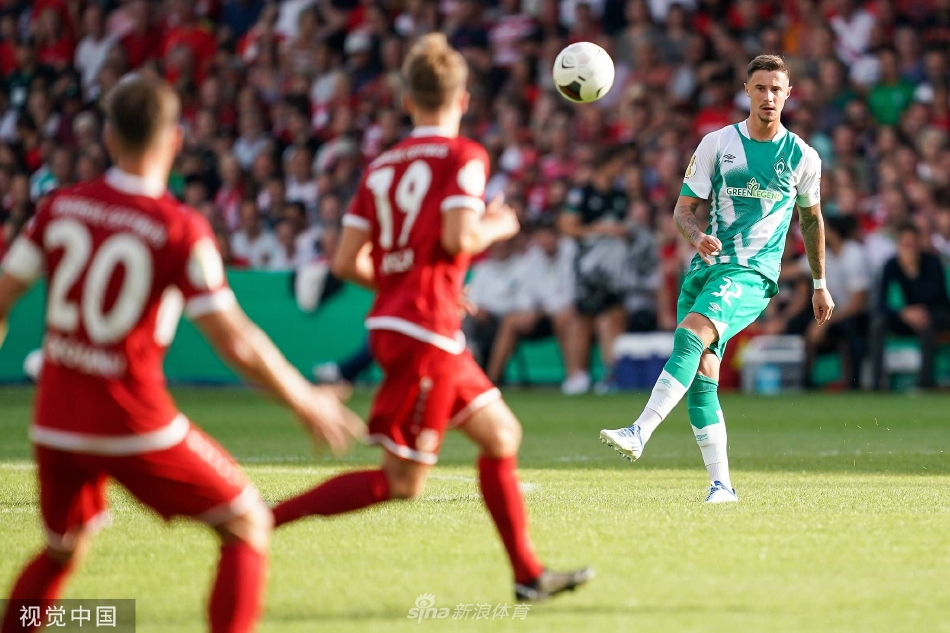 不莱梅后卫高高跃起，力压进攻球员，将传中球头球解围出危险区