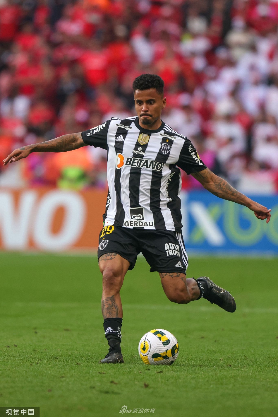 巴西国际前锋在进球后张开双臂，面向看台激情怒吼庆祝，身后是欢呼雀跃的队友。