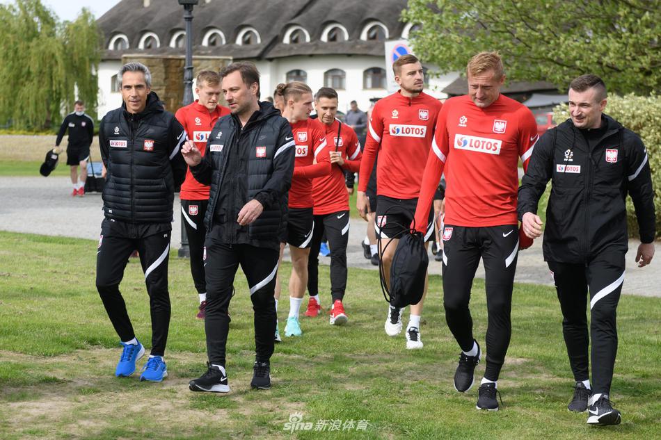 训练场上，波兰队后卫线球员正在进行高强度折返跑，绿茵场上的动感身影与远处静谧的树林构成一幅充满活力的备战画卷。